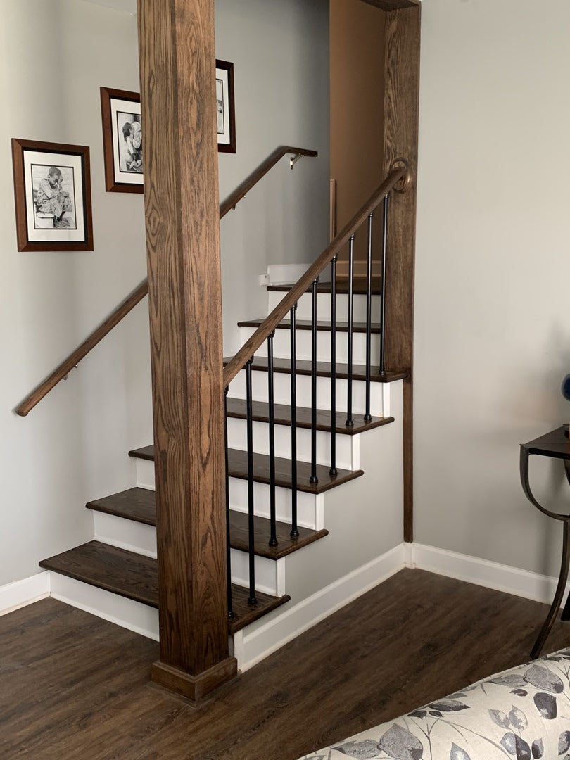 Wooden staircase with metal railing in a home interior setting.